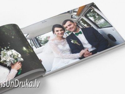 Atvērta kāzu fotogrāmata, kurā redzama līgava un jaunais pāris automašīnā