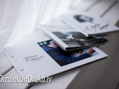 Uz palodzes novietota kāzu fotogrāmata un citi personalizēti albumi