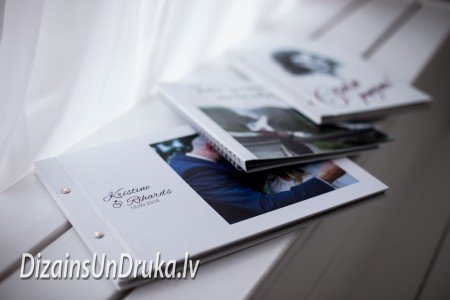 Uz palodzes novietota kāzu fotogrāmata un citi personalizēti albumi