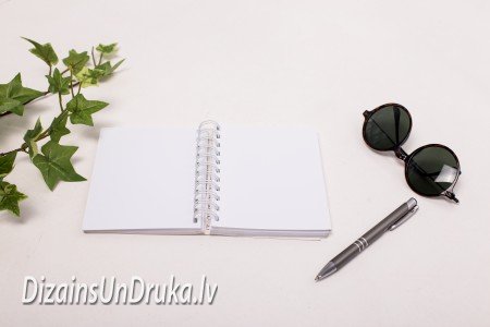 Open spiral-bound notebook with pen and sunglasses, binding design