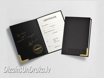 Melni diplomu vāki ar zelta stūriem un atvērumā redzamu sertifikātu